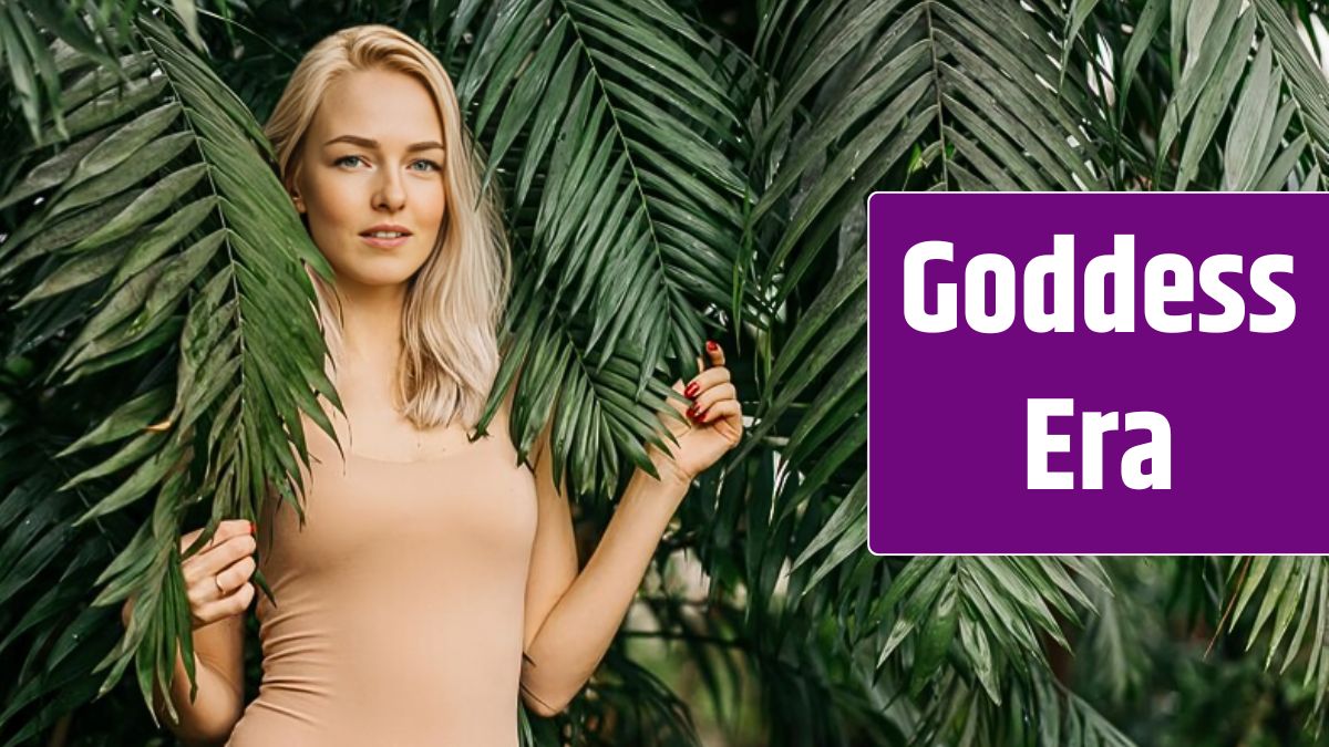 Young woman's face surrounded by tropical leaves. Closeup portrait of magnificent lady with natural nude makeup, perfect skin, blonde hair.