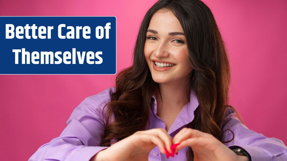 Cheerful smiling young woman showing heart sign against pink background.