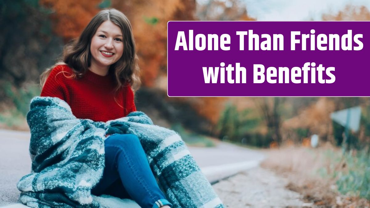 Portrait of smiling girl sitting by road during autumn.